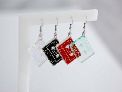 Customizable acrylic cassette tape earrings in various colors.