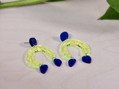 Acrylic boho geometric dangle earrings in fluorescent green and dark blue.